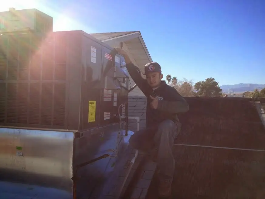 HVAC technician performing Air Duct Cleaning on a rooftop unit in Clarendon Hills
