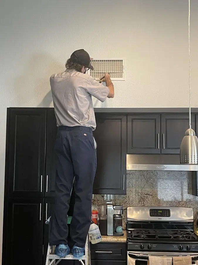 Technician inspecting an air vent during HVAC service in Clarendon Hills